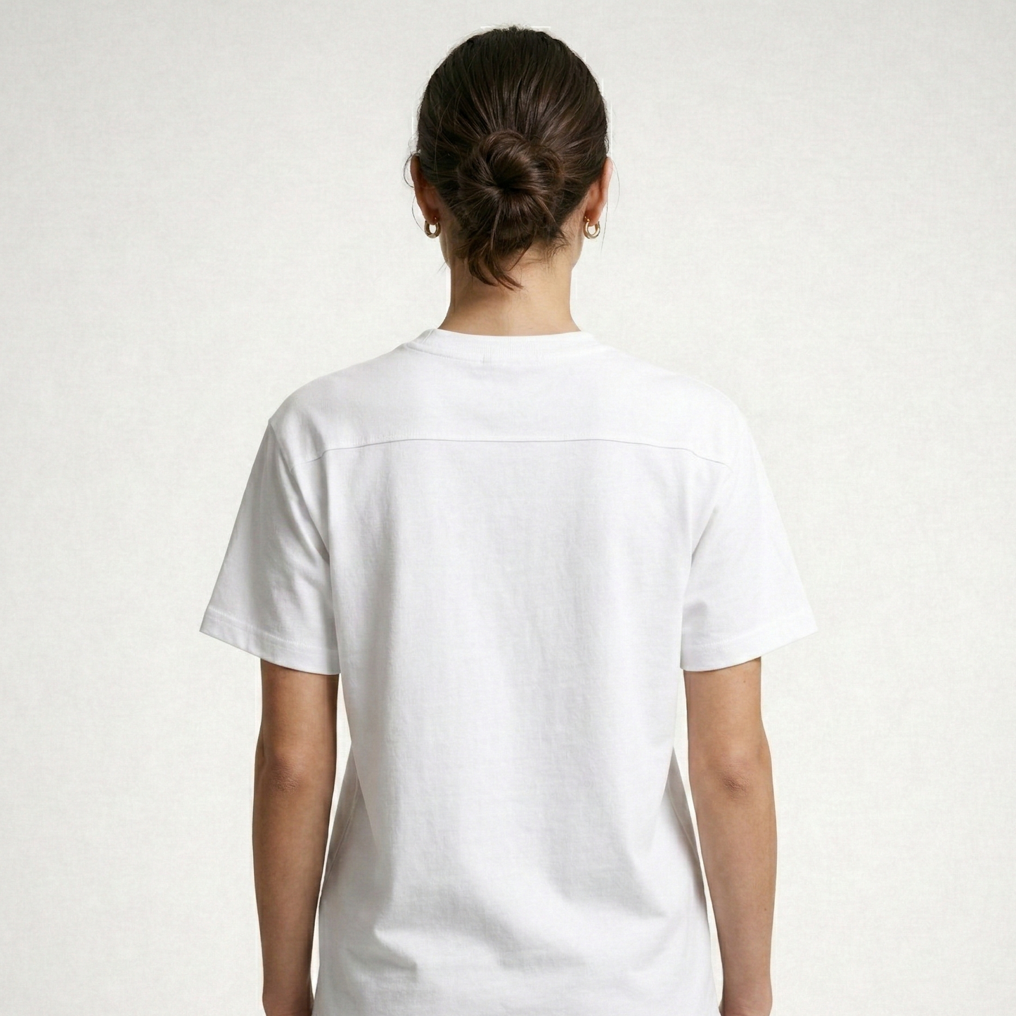 Person wearing a white t-shirt on a plain background