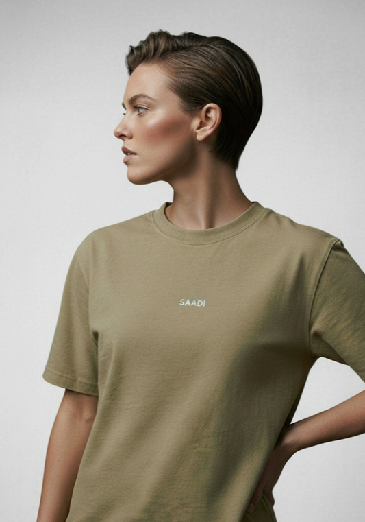 Person wearing a green t-shirt with a logo on a plain background