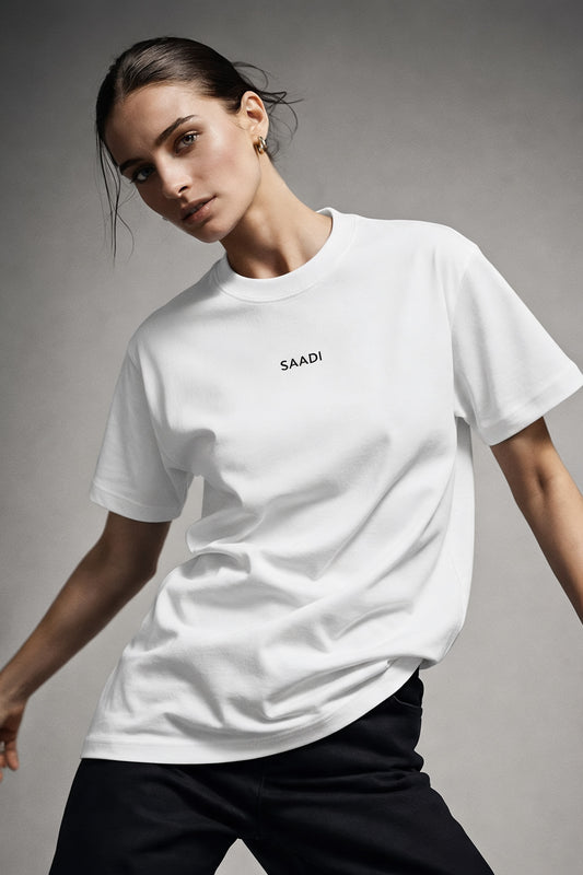 Person wearing a white t-shirt with 'SAADI' logo against a gray background
