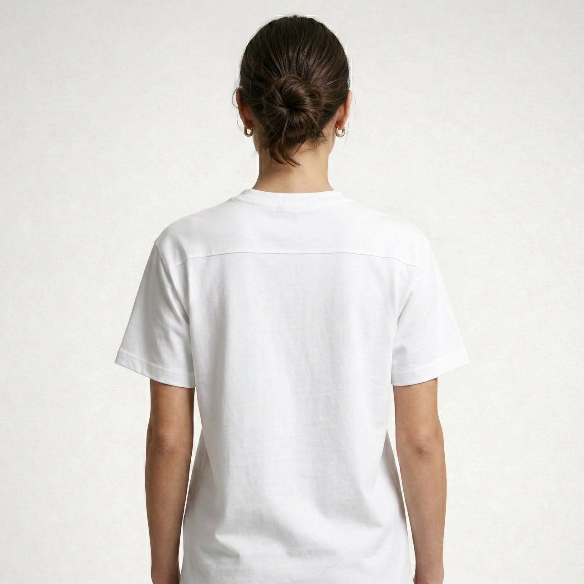 Person wearing a white t-shirt on a plain background